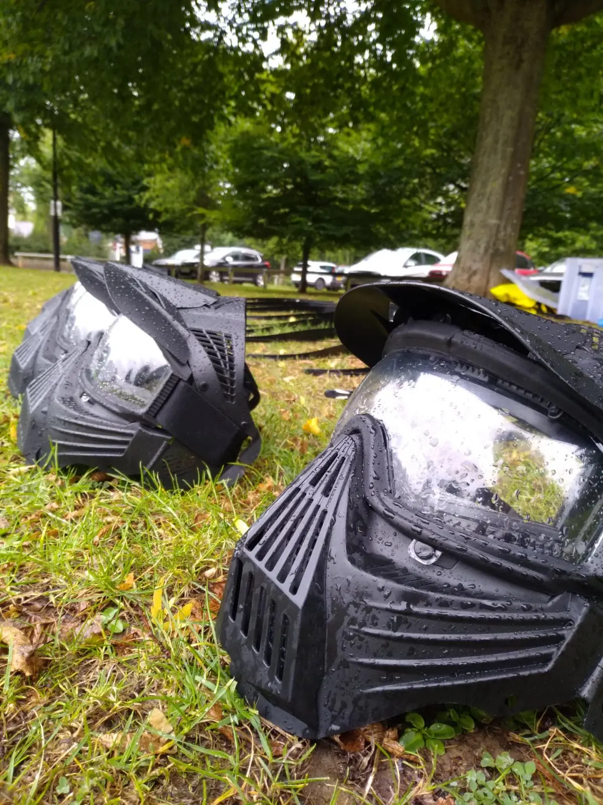 Two full-face protective masks resting on grass