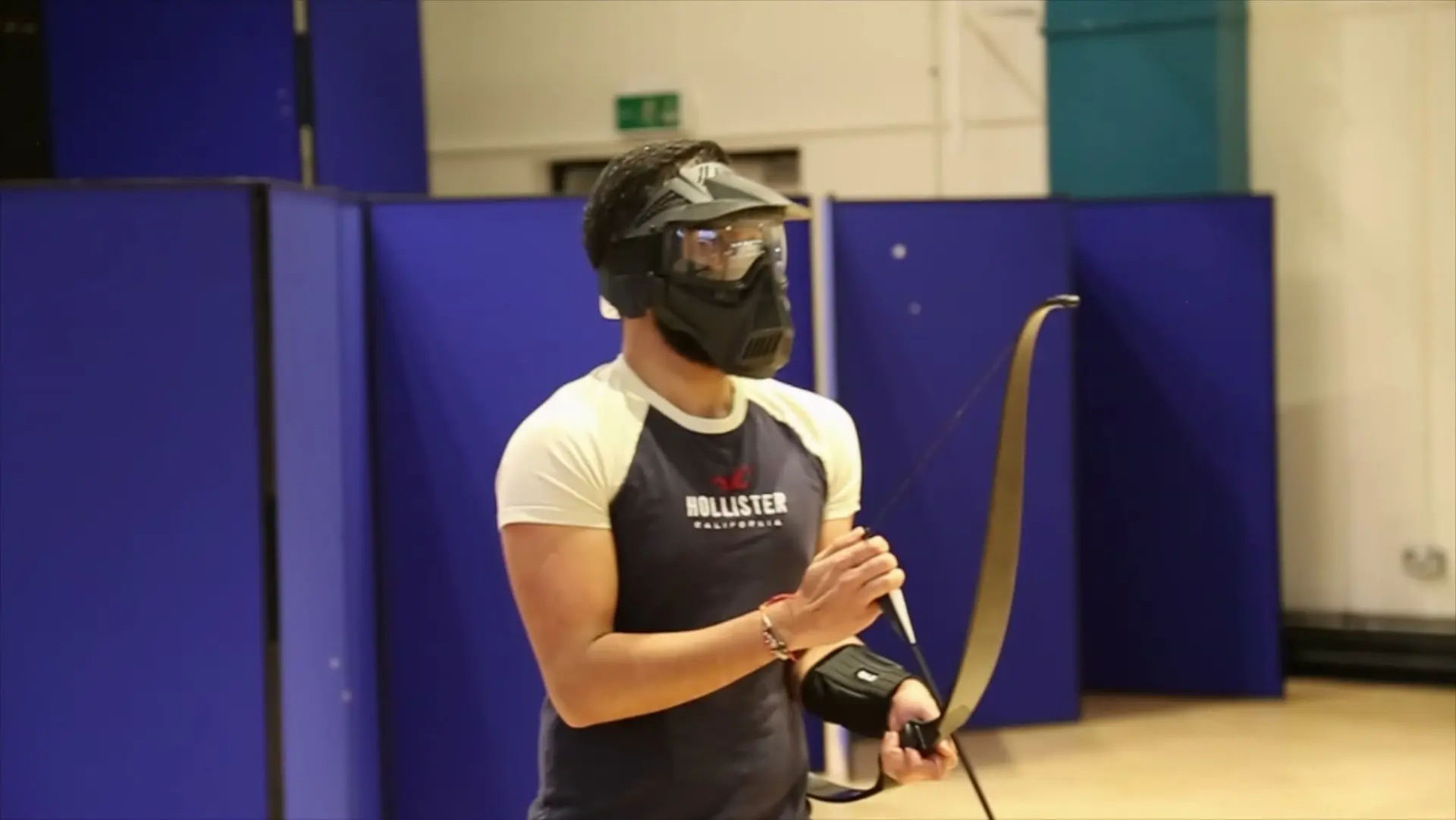 A masked player holds a bow, ready for the next round